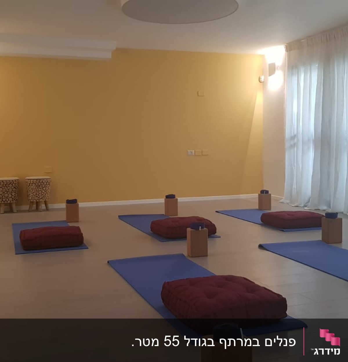 רצפת פרקט בחדר יוגה עם מזרנים וכריות